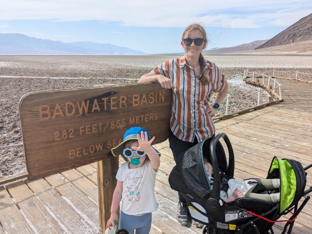 A family stands in front of a sign that reads "Badwater Basin - 282 Feet Below Sea Level"